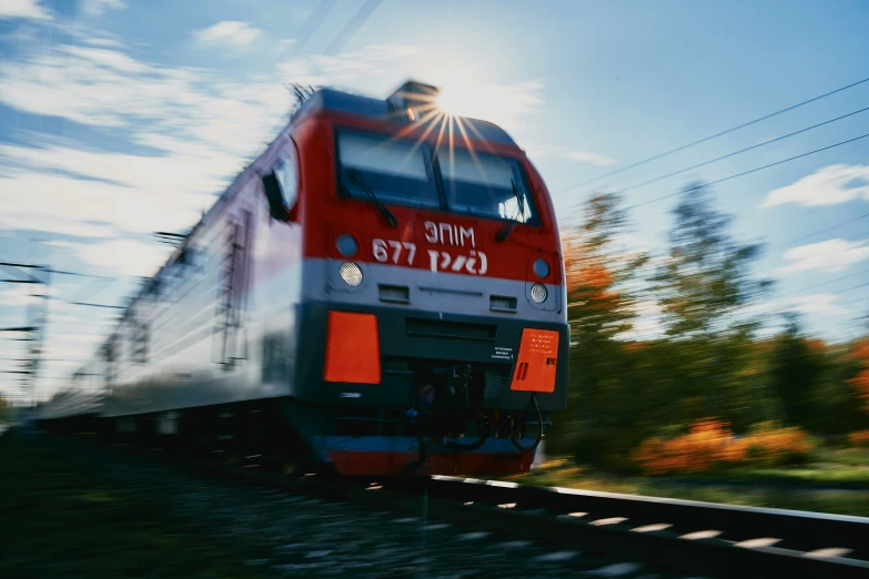 a red and white train traveling down tracks