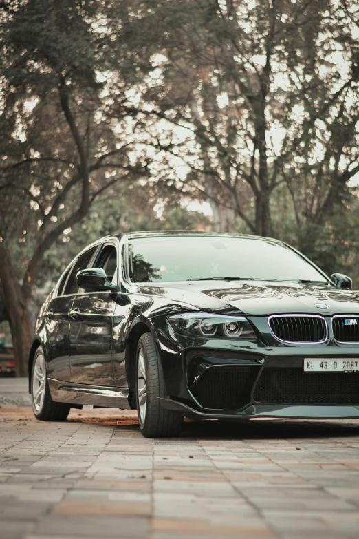 there is a bmw on the sidewalk by a tree