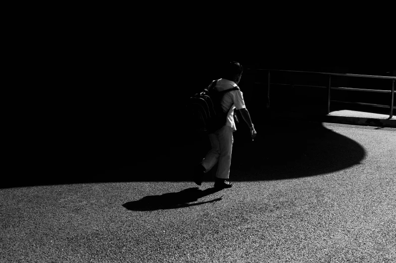 a person walking in the dark towards the side walk