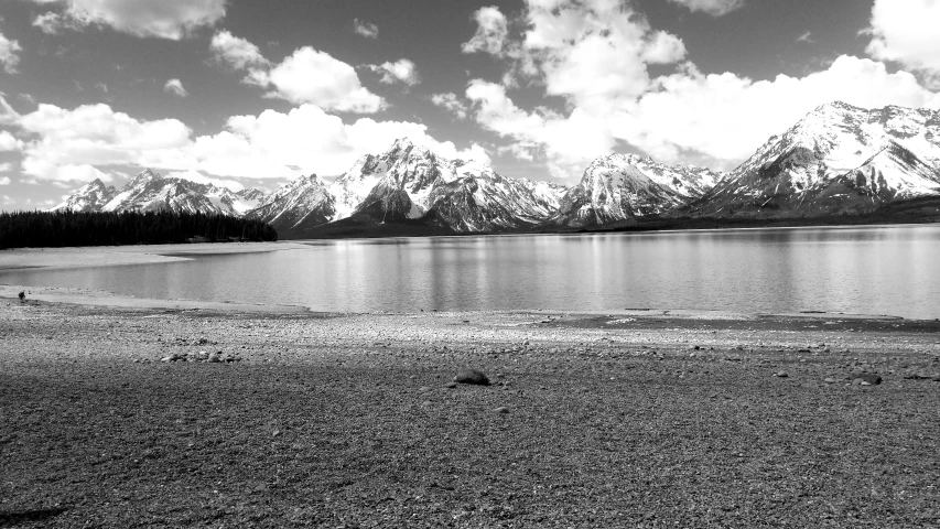 a boat out on the water with the mountains in the background