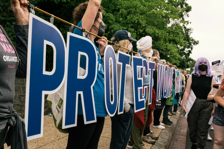 several protesters with protest signs and wearing black shirts