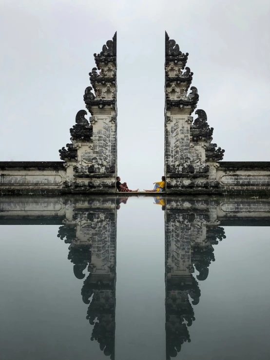 a long tall stone gate with statues on top