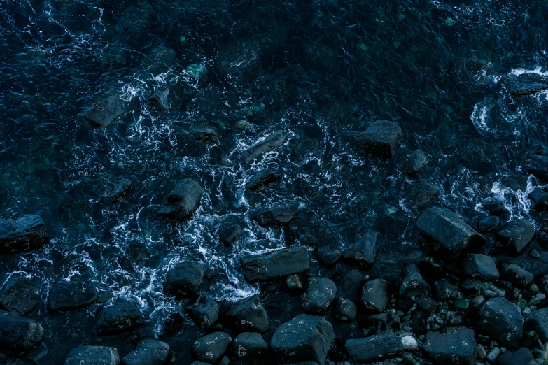 dark blue water that has rocks and gravel on it