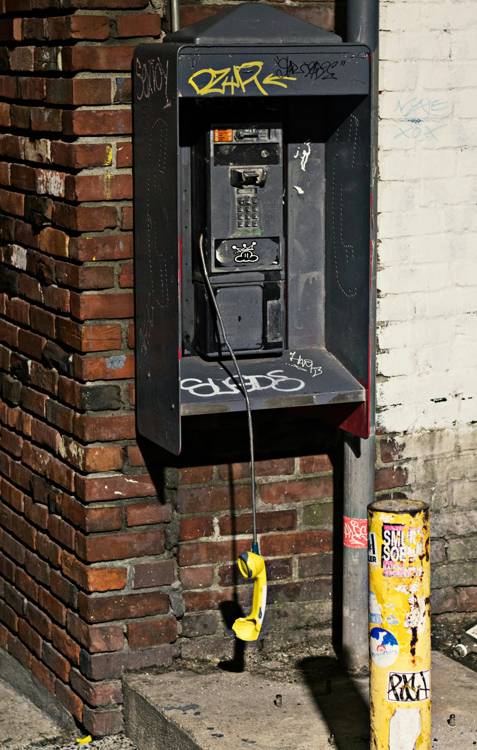 an old public phone is on the corner of a building