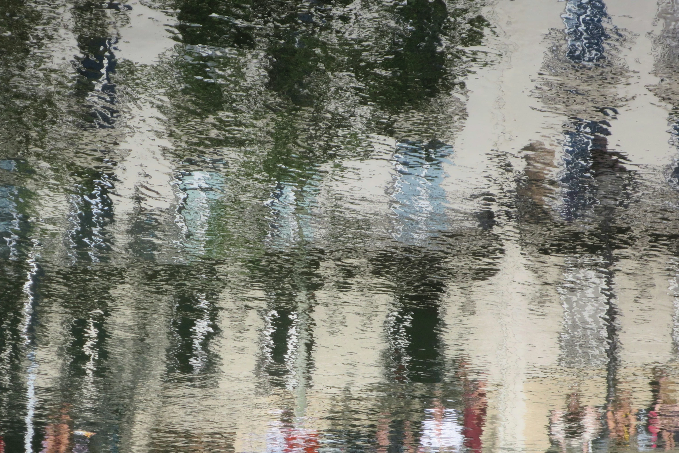 a water surface with a reflection and colors of trees