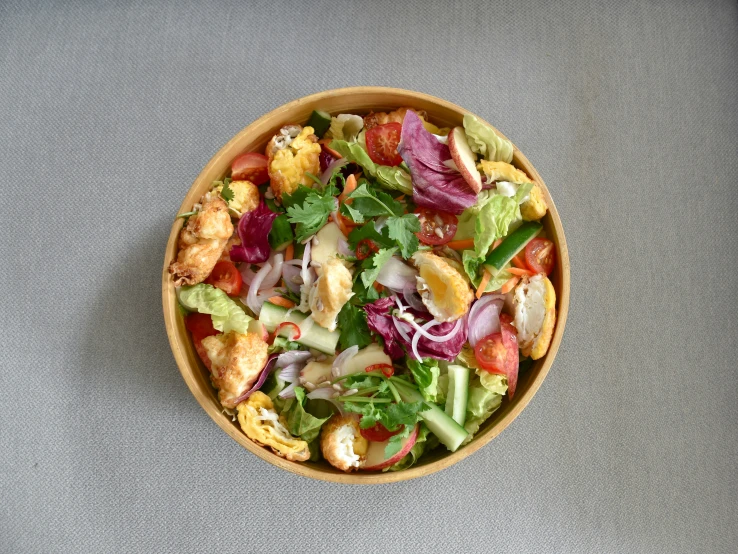 a bowl of mixed salad with some type of topping