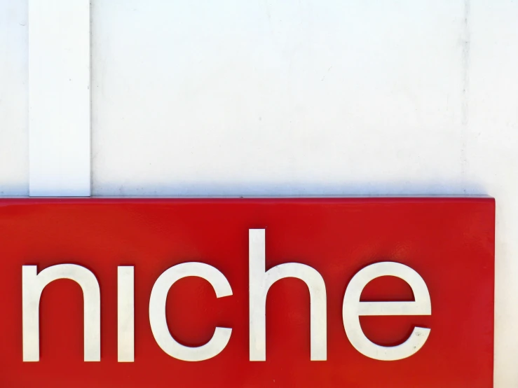 a close up of a red sign with the word niche