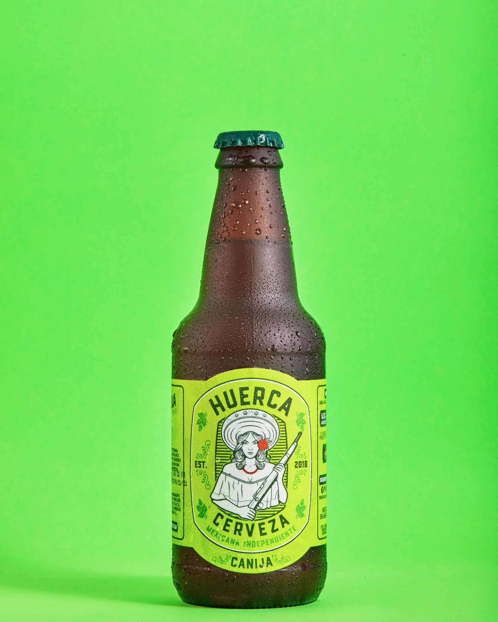 a beer bottle is sitting against a green background