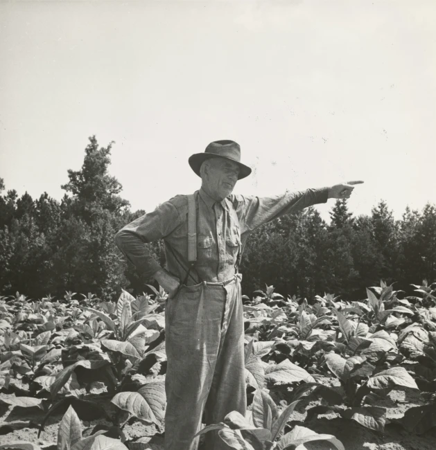 a man in a field holding out soing to the side