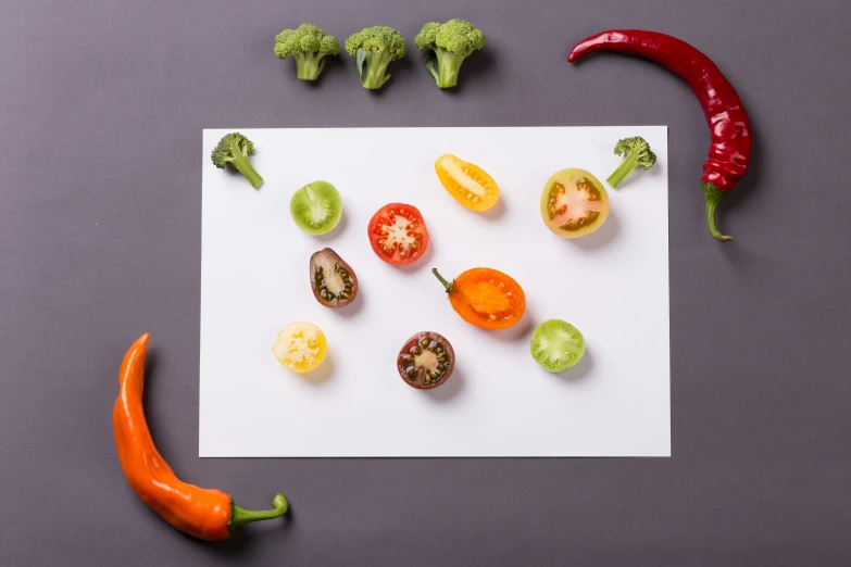 a white board with a red chili, broccoli, peppers and avocado