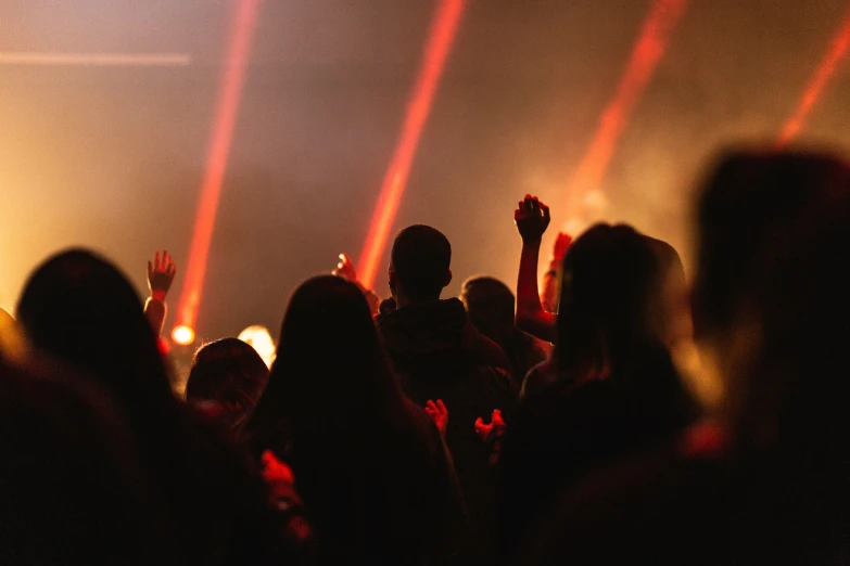 several people at a night club looking on a person raising his hands in the air