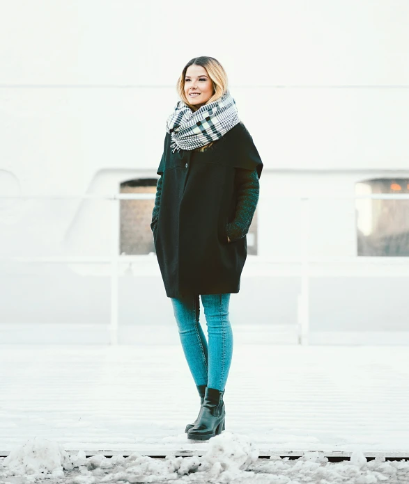 a woman in a coat, scarf and snow boots