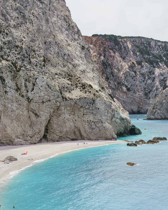 people are swimming and sunbathing on the beach