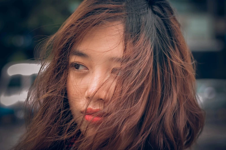 an asian woman with brown hair looking forward