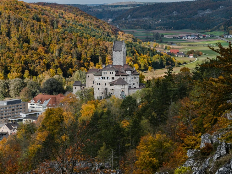 a big building sitting among some trees on the hillside