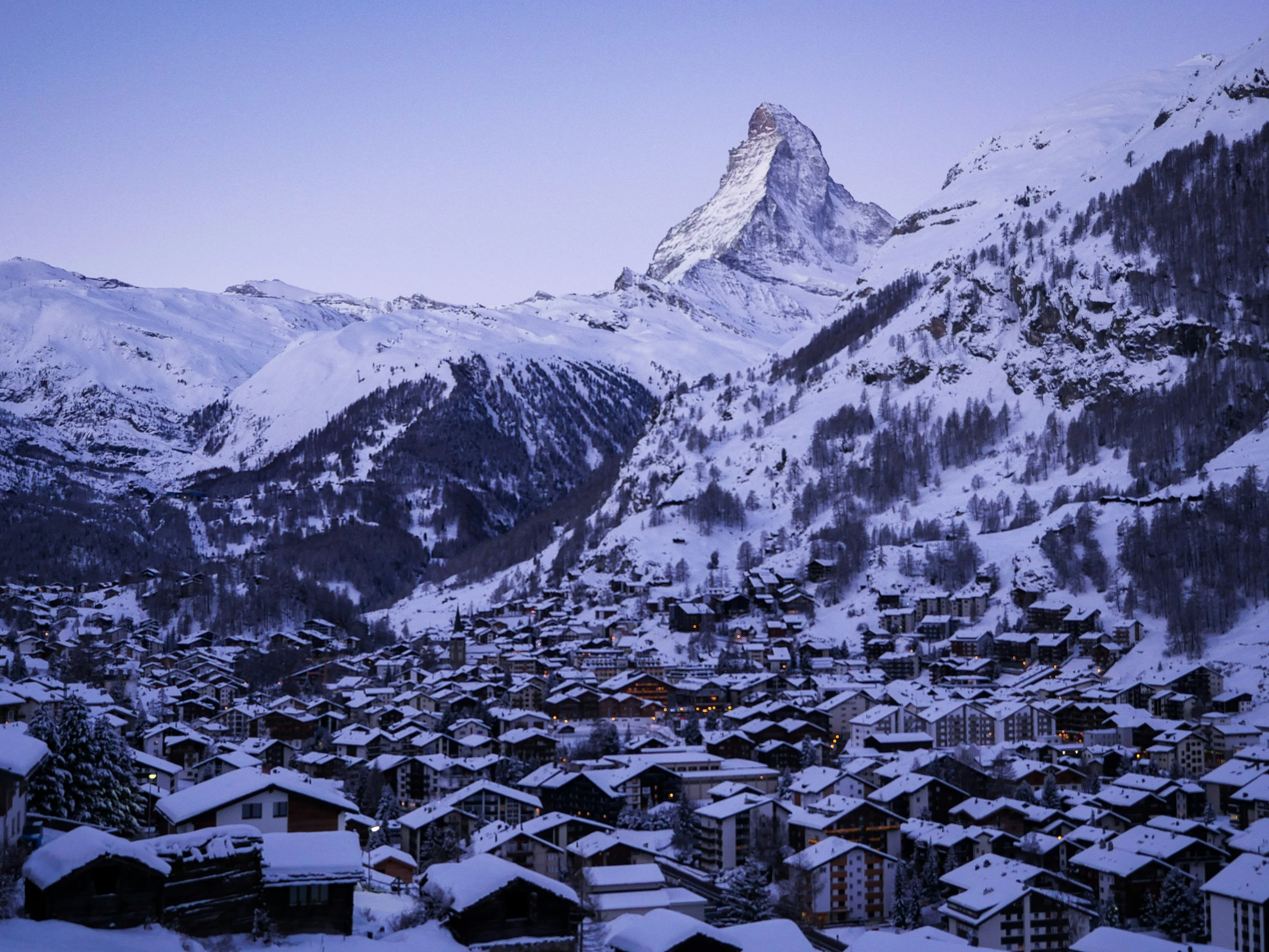 snow covered village surrounded by mountain in winter