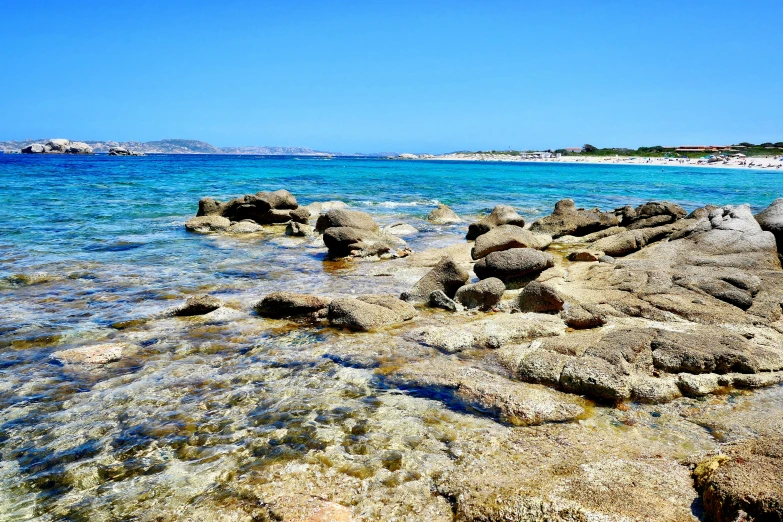 a body of water with rocks and small sand