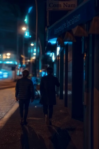 two people walking down the street at night