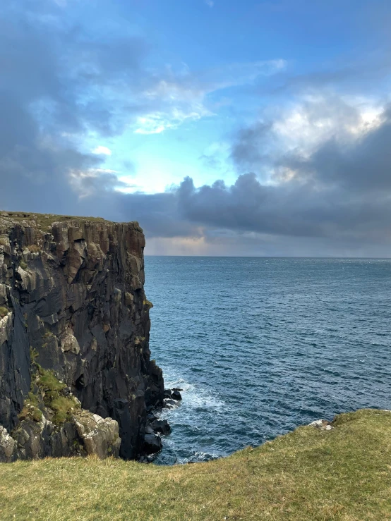 the large cliffs are covered with grass and cliff