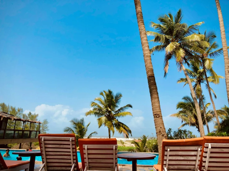 three chairs sitting near one another in front of the beach