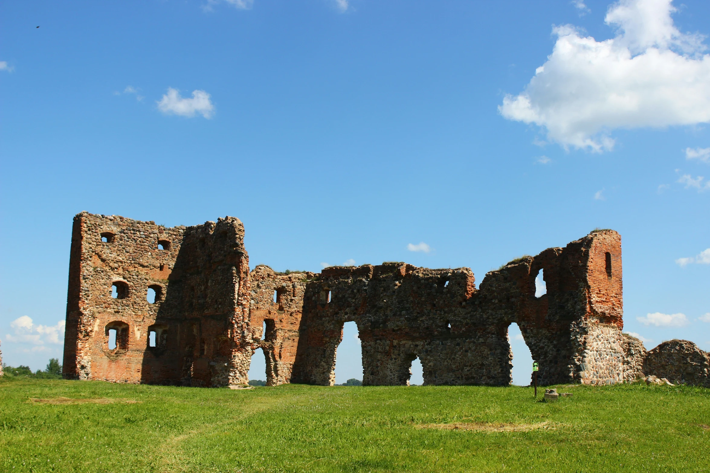 a large stone building sitting in the middle of a lush green field