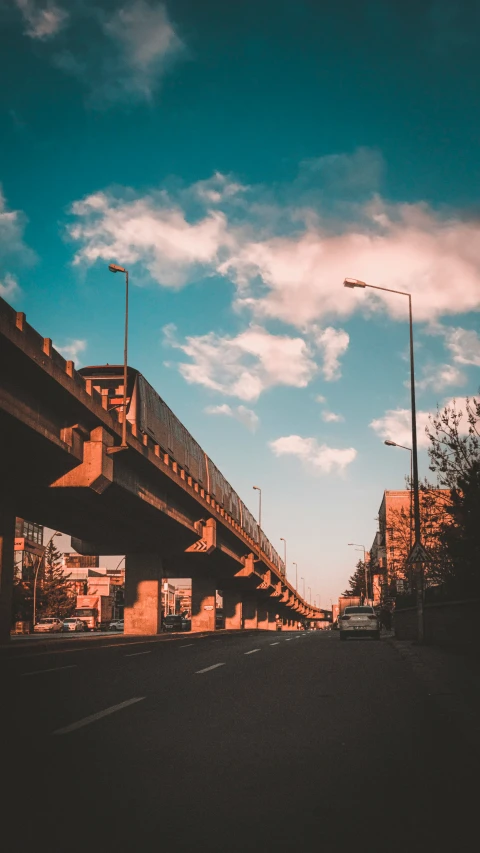 an overpass on the side of a road under a cloudy sky