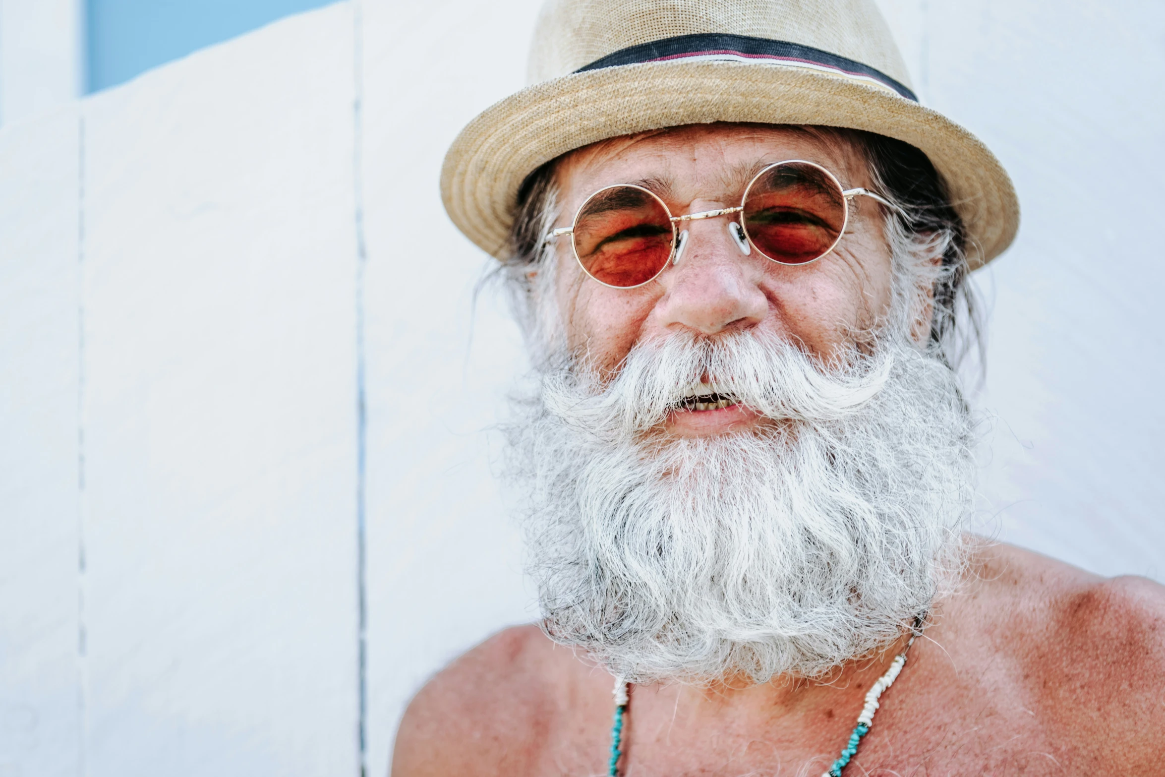 an old man with a big white beard wearing sunglasses and a hat