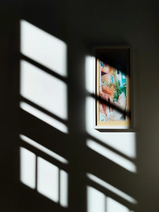 sunlight streaming in from an overhead window on a wall