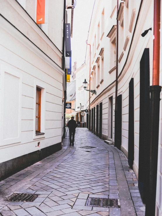 the pedestrian is walking down the narrow street