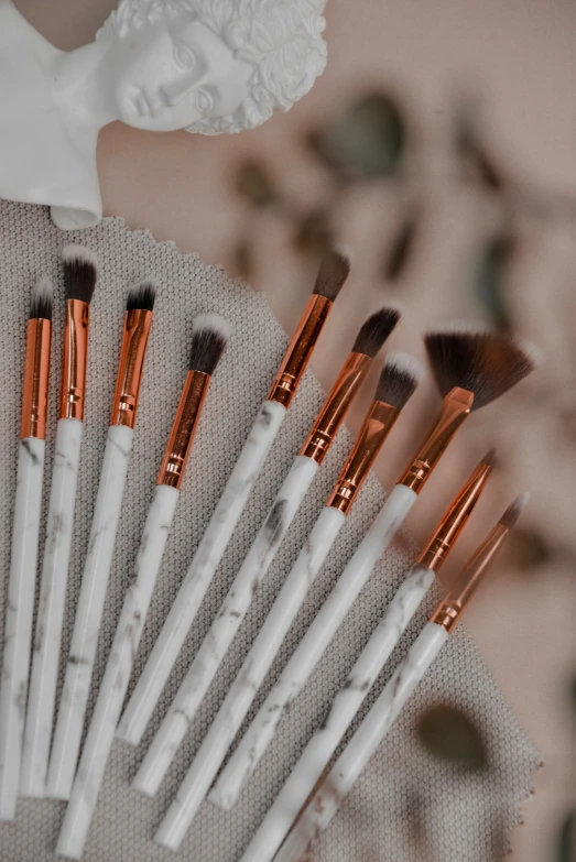 there are many white and gold brushes in this set