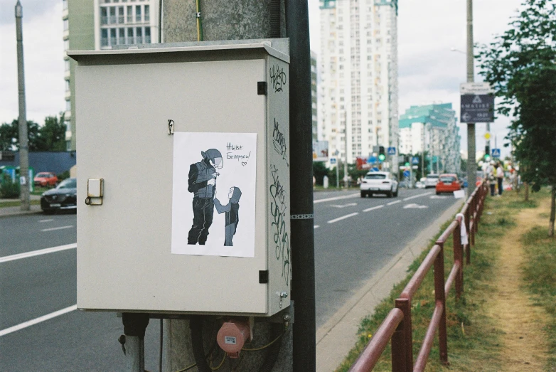 a box on a telephone pole by a street