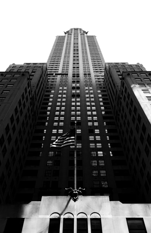 a view up the side of a tall building with an american flag flying