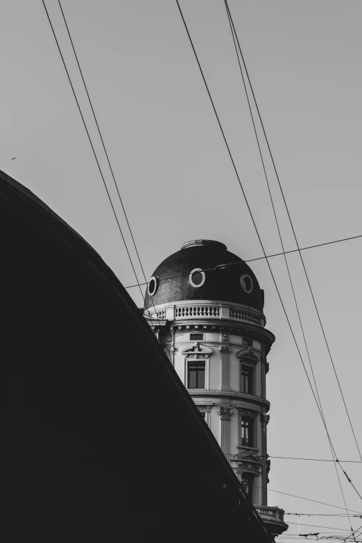 a black and white image of a tower with power lines in the background