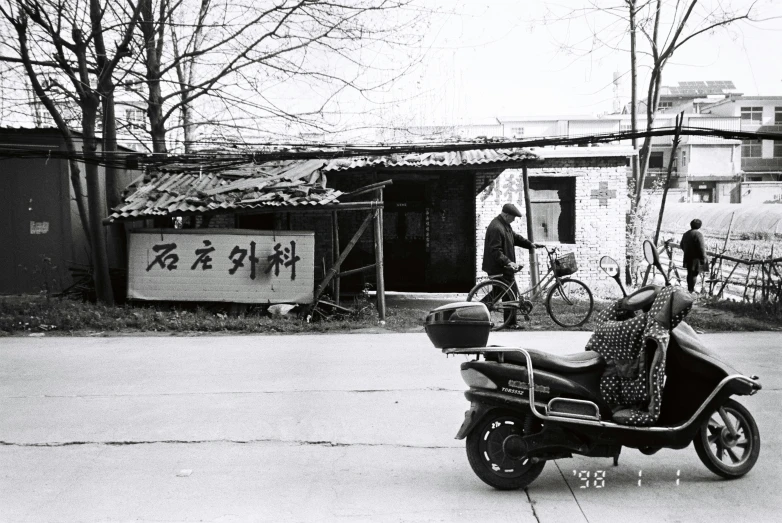 a old motorcycle and a trailer with people walking on the street