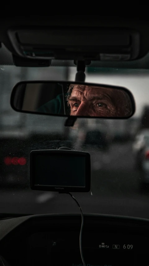 the side mirror on a car that has a man taking a po