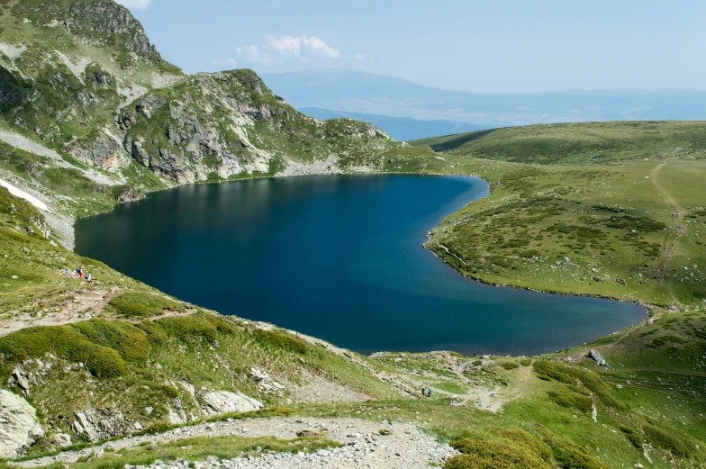 blue lake surrounded by lush green mountains and water