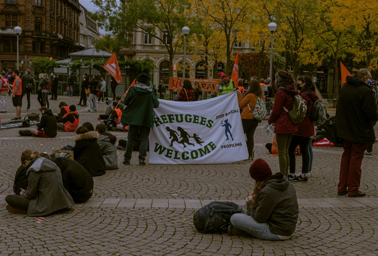 people gathered at the city square and one person is sitting on the ground