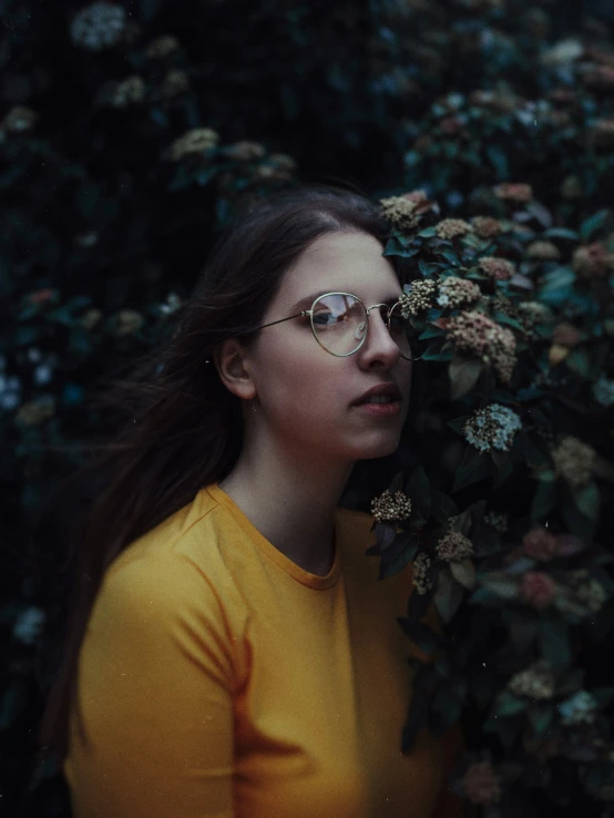 the girl stands behind flowers in glasses