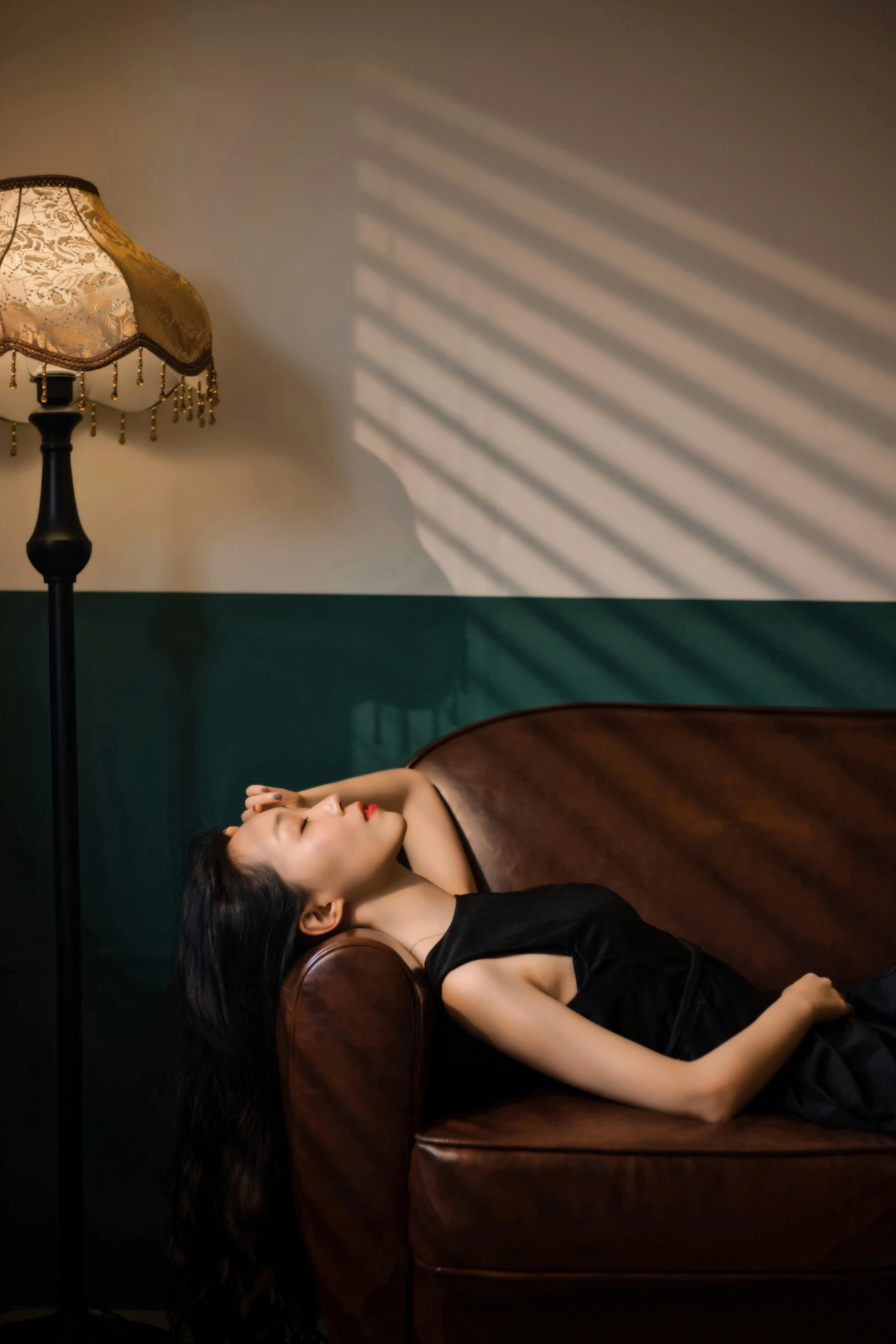 a woman laying on top of a couch next to a lamp