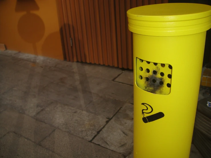 yellow trash can with black dots and smoke on it