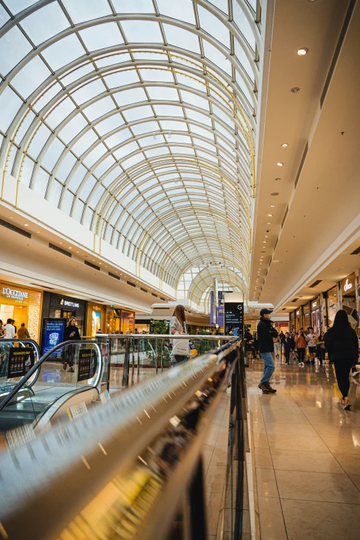 a woman walking down an escalator in a building