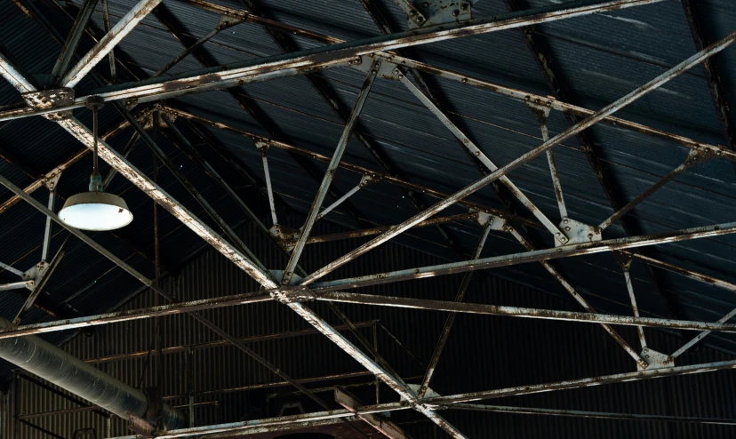 a ceiling with metal pipes and a lamp