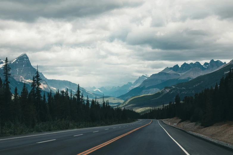 a wide open road with mountains in the distance