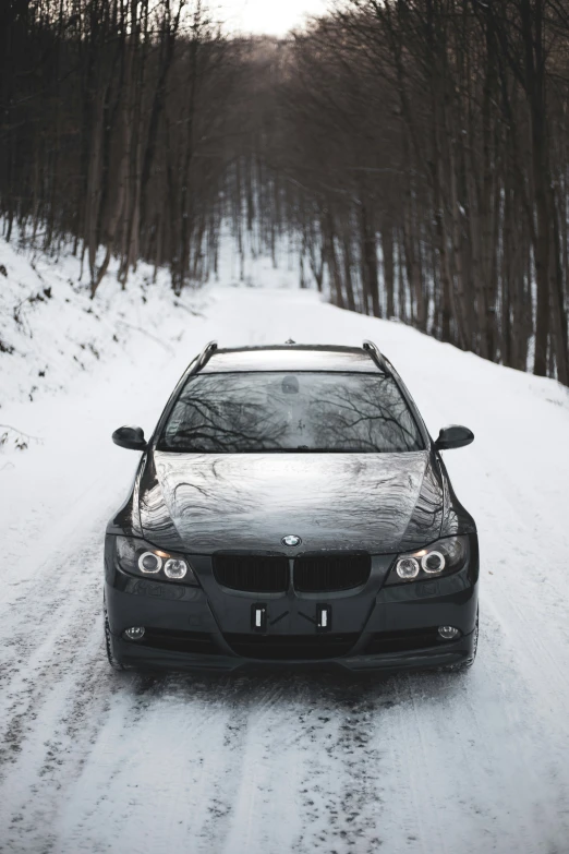 a car is parked in the middle of the road in winter