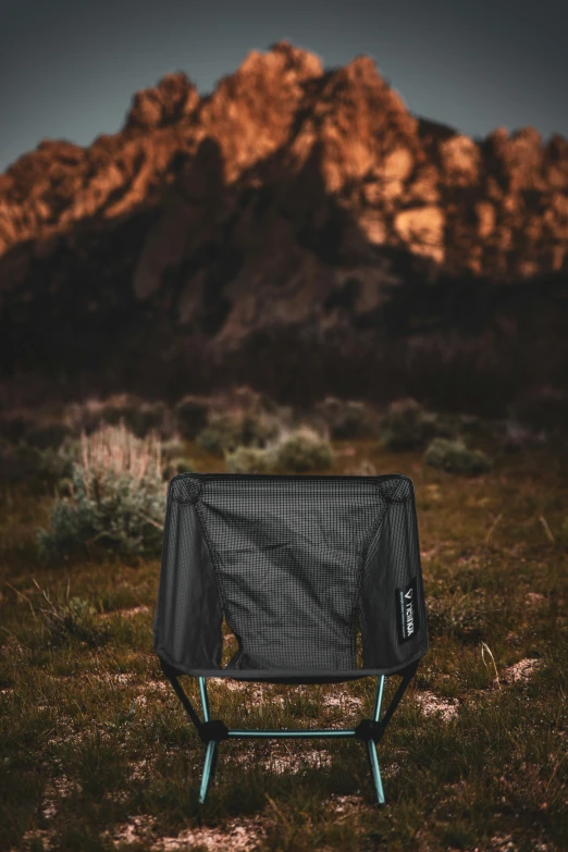 a black and white chair in front of a mountain