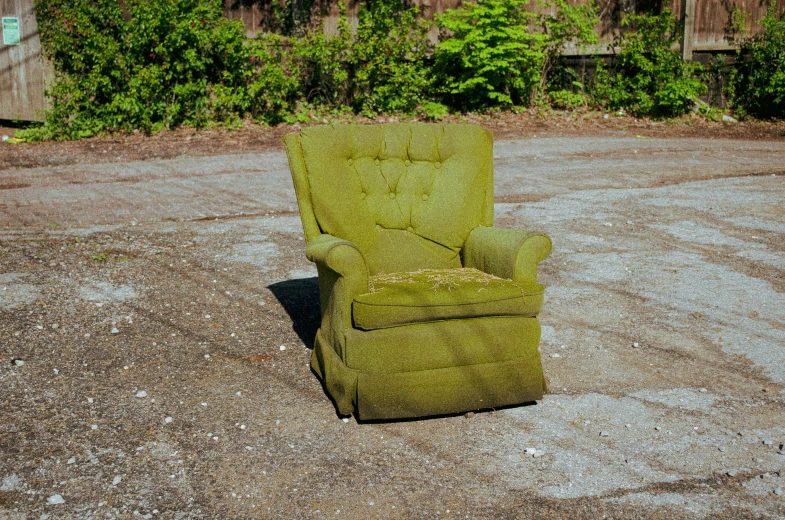 an overstuffed chair sitting in the dirt