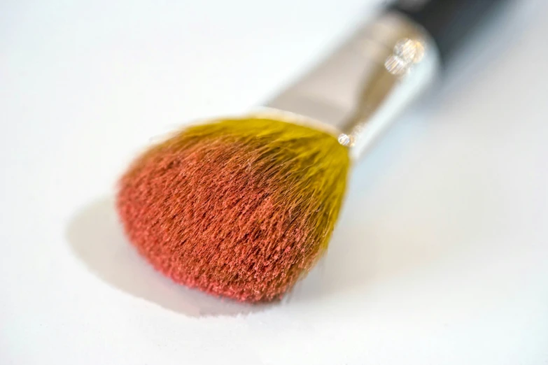 a pink and yellow brush with a white handle