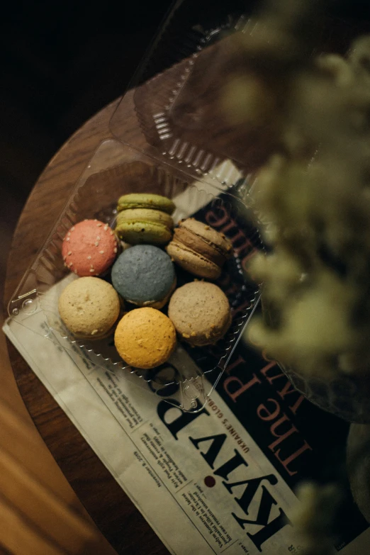 a clear bowl filled with colorful macaroons sitting on top of a table