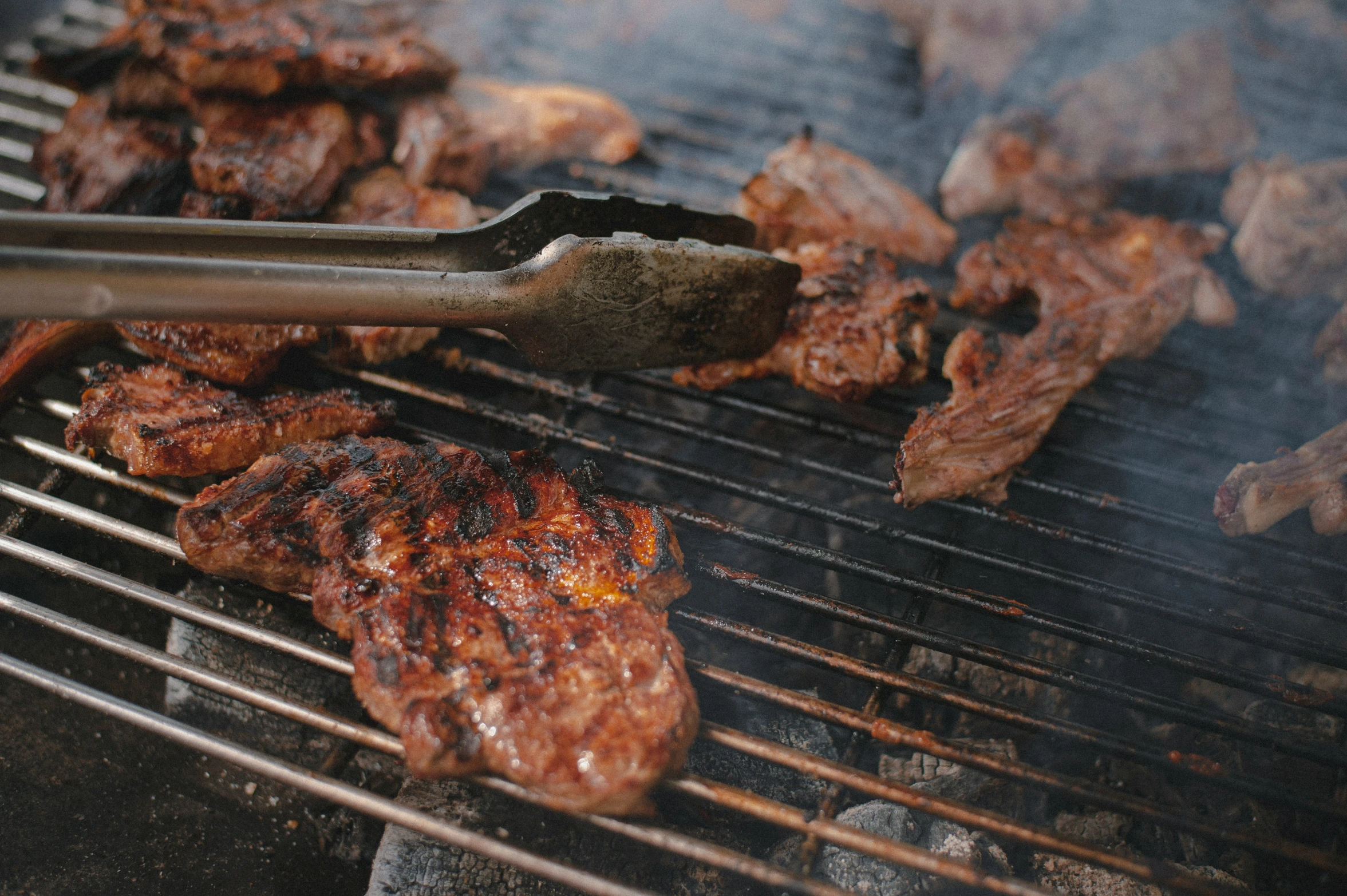 hamburger patties being grilled on a charcoal grill