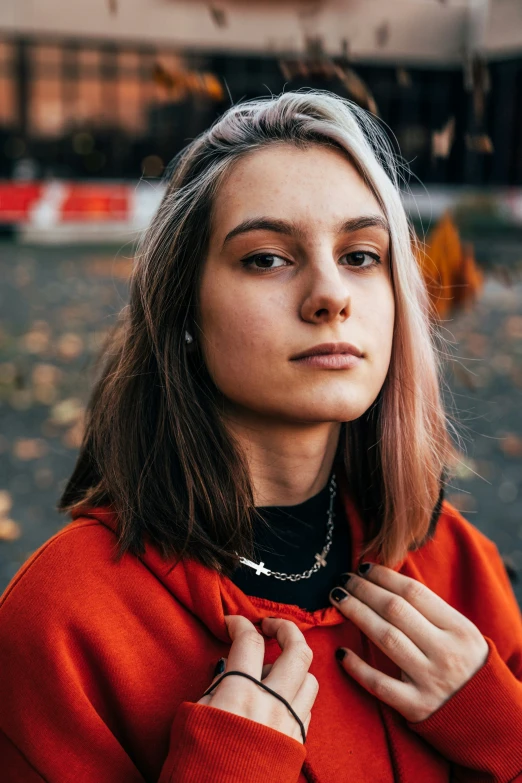 a young woman wearing a red sweater looking into the distance